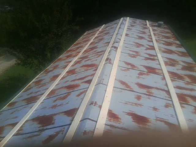 Rusted metal roof panels with new wood purlins before replacement — Storm Damage Roof Repair in West Columbia by Roofing Brothers