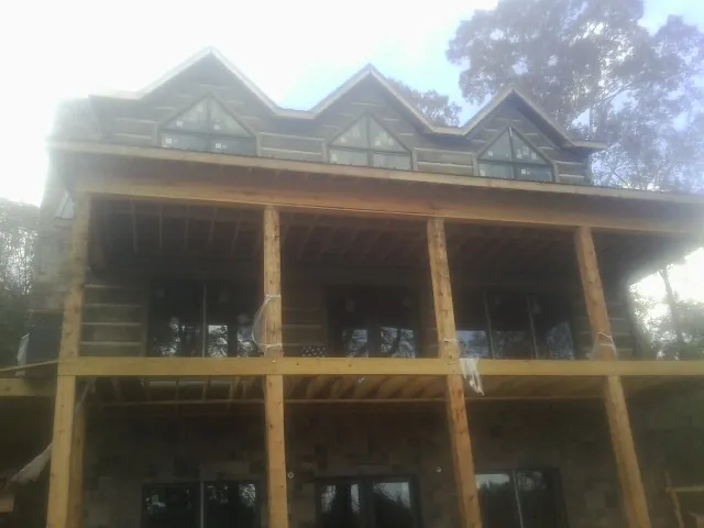 Dormers and porch framing on a large log home under construction — Roof Coating work by our crew in West Columbia